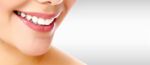 Pretty woman smiling against a grey background with copyspace
